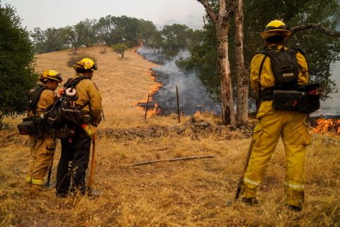 Firefighters watch the Glass Fire slowly creep across a clearing near Calistoga on September 29.