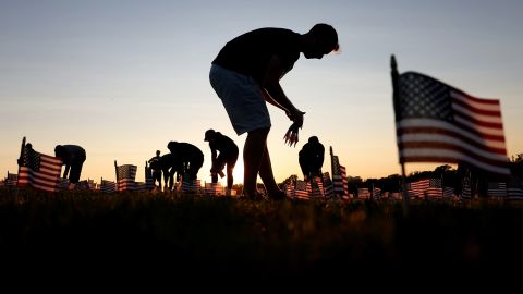 Volunteers with the 'COVID Memorial Project' install 20,000 American flags on the National Mall.