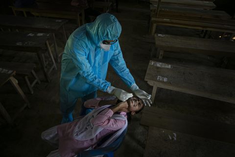 A health worker tests a student for Covid-19 after classes started at a college in the Indian village of Jhargaon on September 30. 