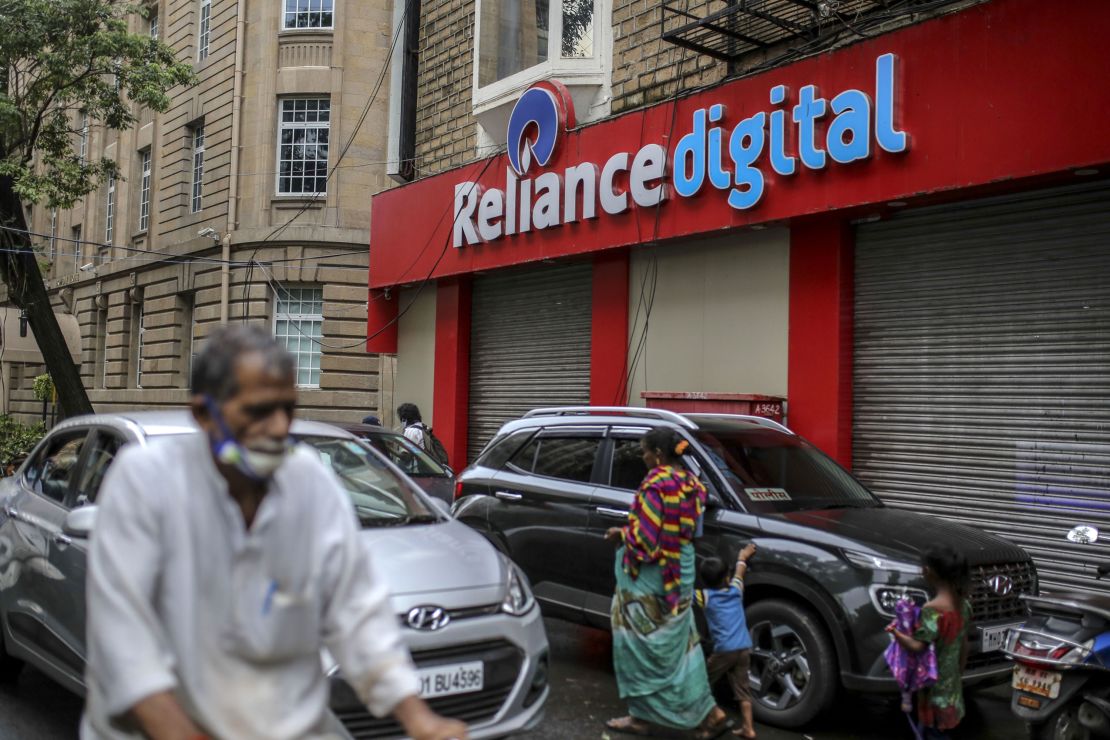 Pedestrians walking past a store of Reliance Digital Retail, a subsidiary of Reliance Industries, in Mumbai  in July.