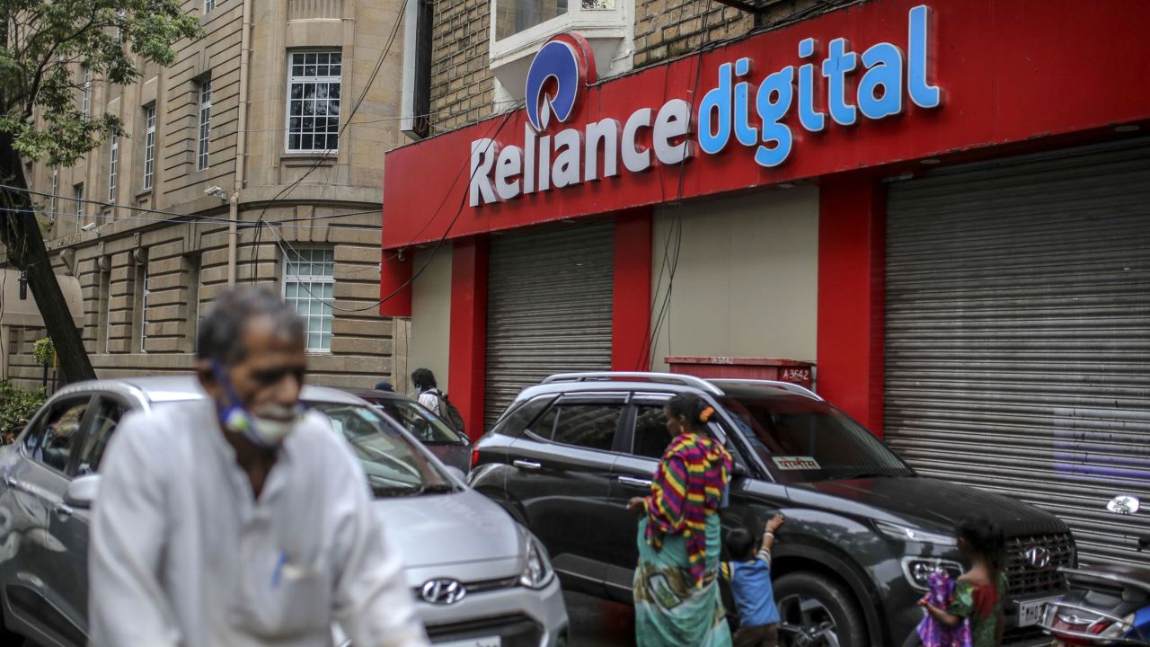 Pedestrians walking past a store of Reliance Digital Retail, a subsidiary of Reliance Industries, in Mumbai in July.