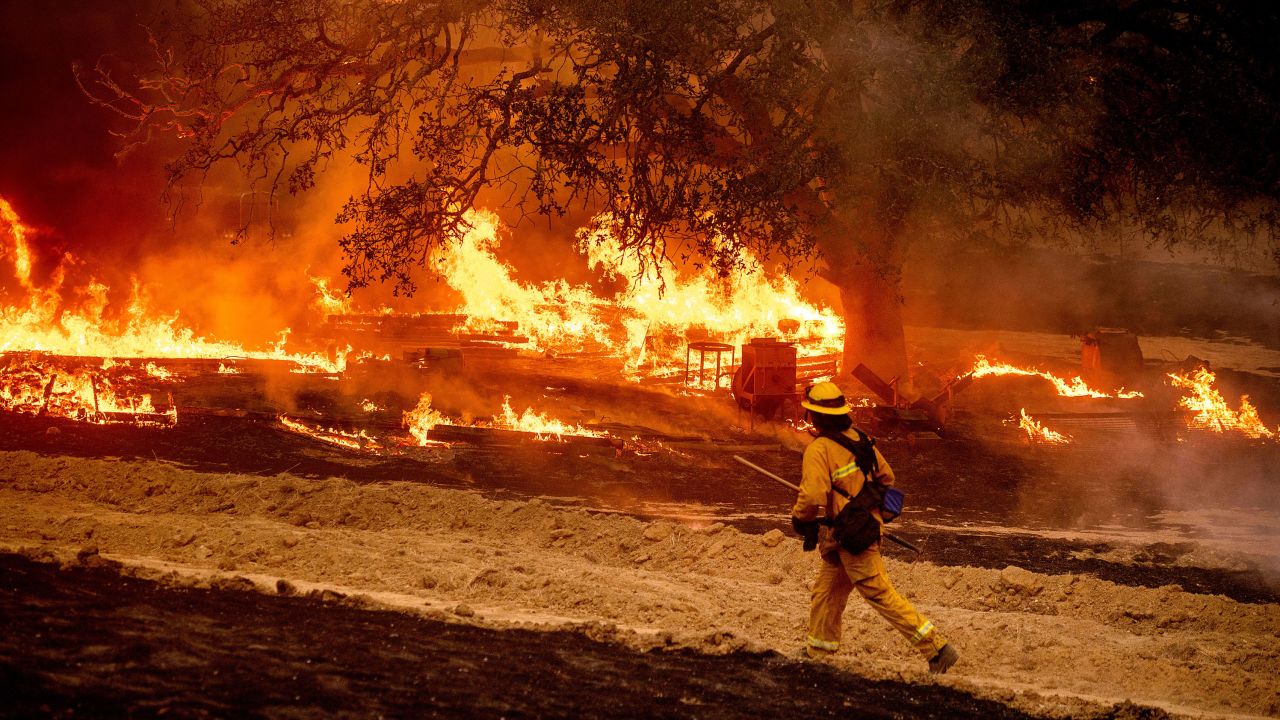 A firefighter passes flames while battling the Glass Fire in a Calistoga, California,  vineyard on Thursday, October 1, 2020.