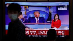 A man wearing a face mask walks near a TV screen reporting about U.S. President Donald Trump and first lady Melania Trump during a news program with a file image of Trump at the Seoul Railway Station in Seoul, South Korea, Friday, Oct. 2, 2020. Trump said early Friday that he and Melania Trump have tested positive for the coronavirus, a stunning announcement that plunges the country deeper into uncertainty just a month before the presidential election. The Korean letters read: "President Donald Trump and first lady Melania Trump tested positive for COVID-19." (AP Photo/Lee Jin-man)