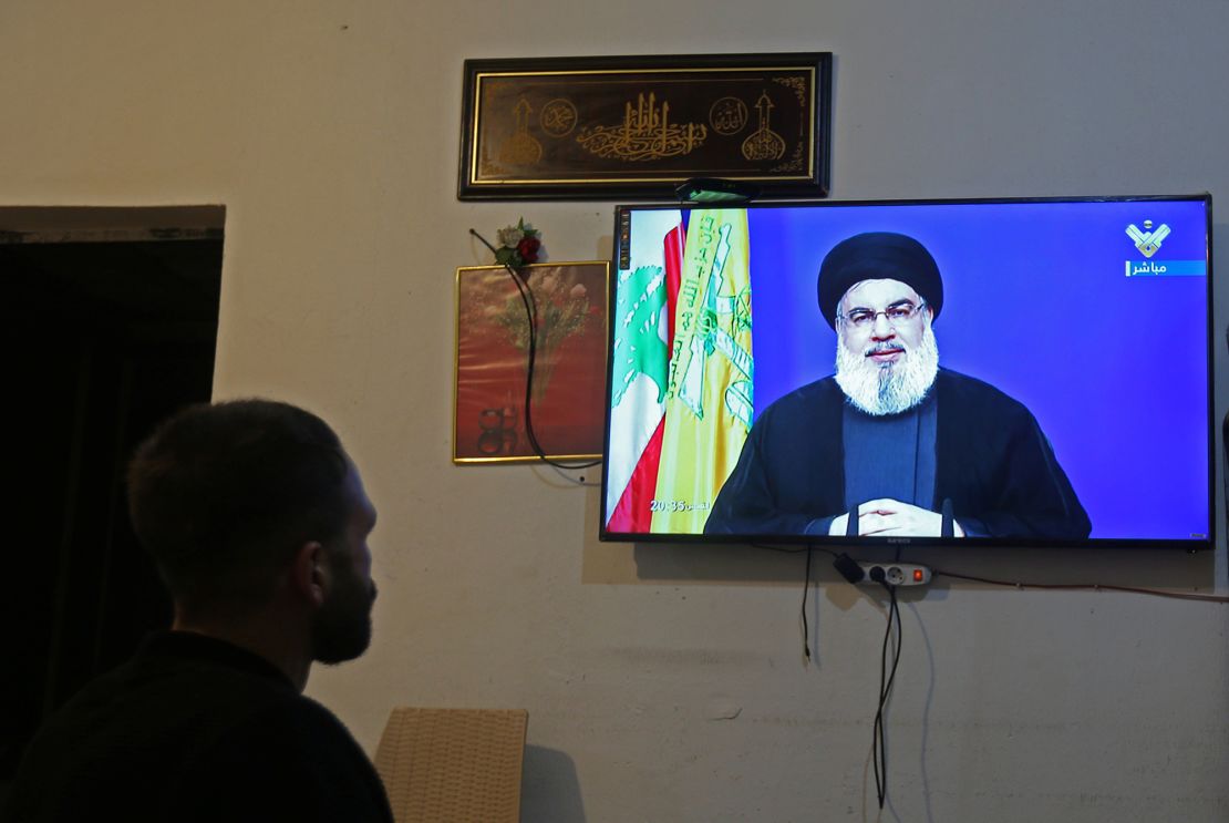 A man watches Lebanon's Hezbollah leader Sayyed Hassan Nasrallah speaking on television, inside a shop in Houla, southern Lebanon on September 29, 2020. 