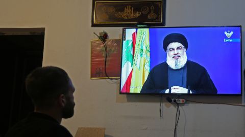 A man watches Lebanon's Hezbollah leader Sayyed Hassan Nasrallah speaking on television, inside a shop in Houla, southern Lebanon on September 29, 2020. 