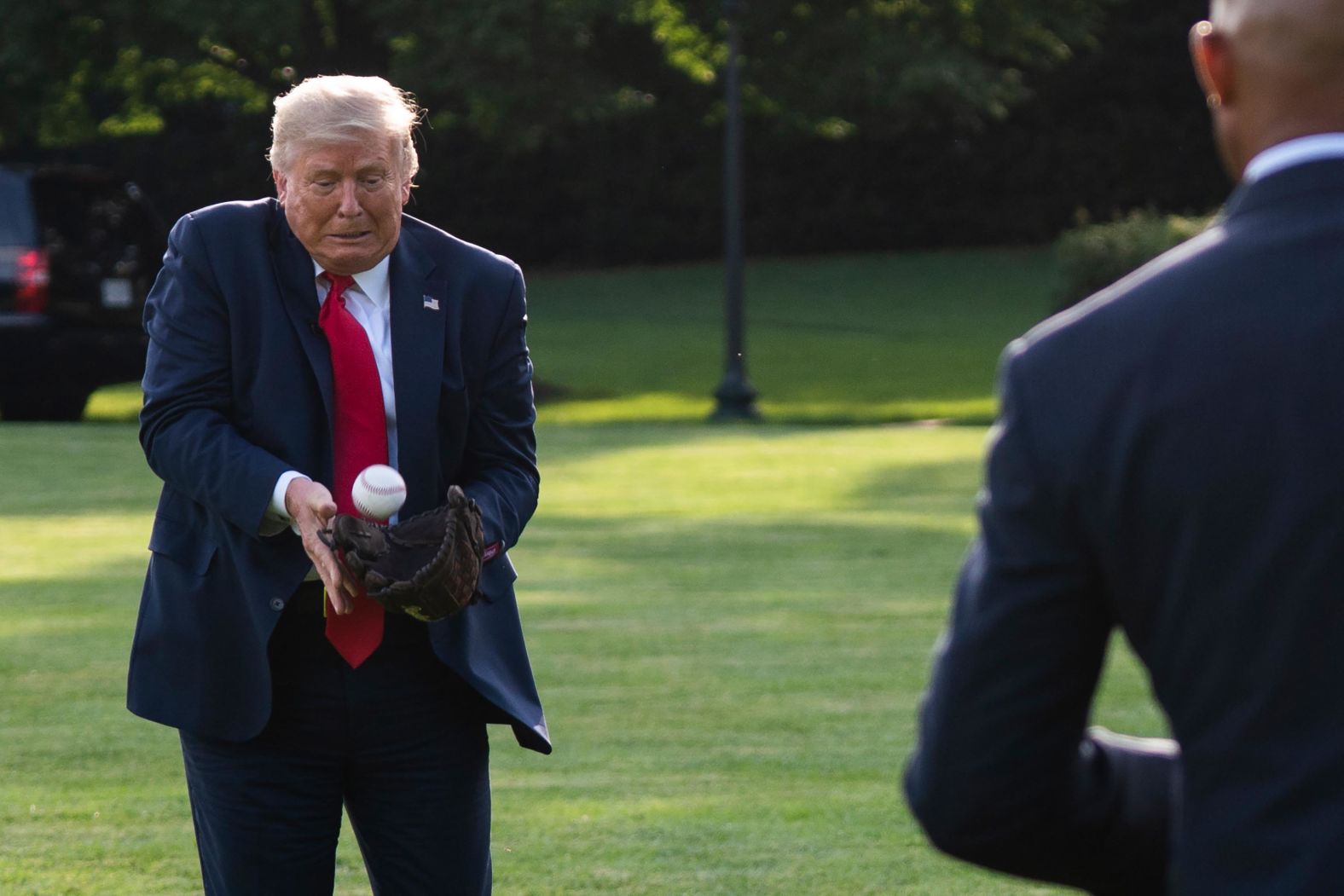 Trump plays catch with former New York Yankees pitcher Mariano Rivera as he greets youth baseball players on the South Lawn of the White House in July 2020.