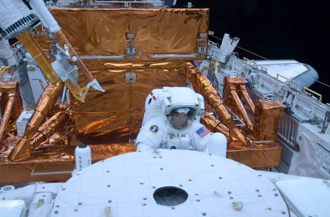 STS-125 Mission Specialist Mike Massimino is pictured here working with the Hubble Space Telescope in the cargo bay of the Earth-orbiting space shuttle Atlantis in 2009.