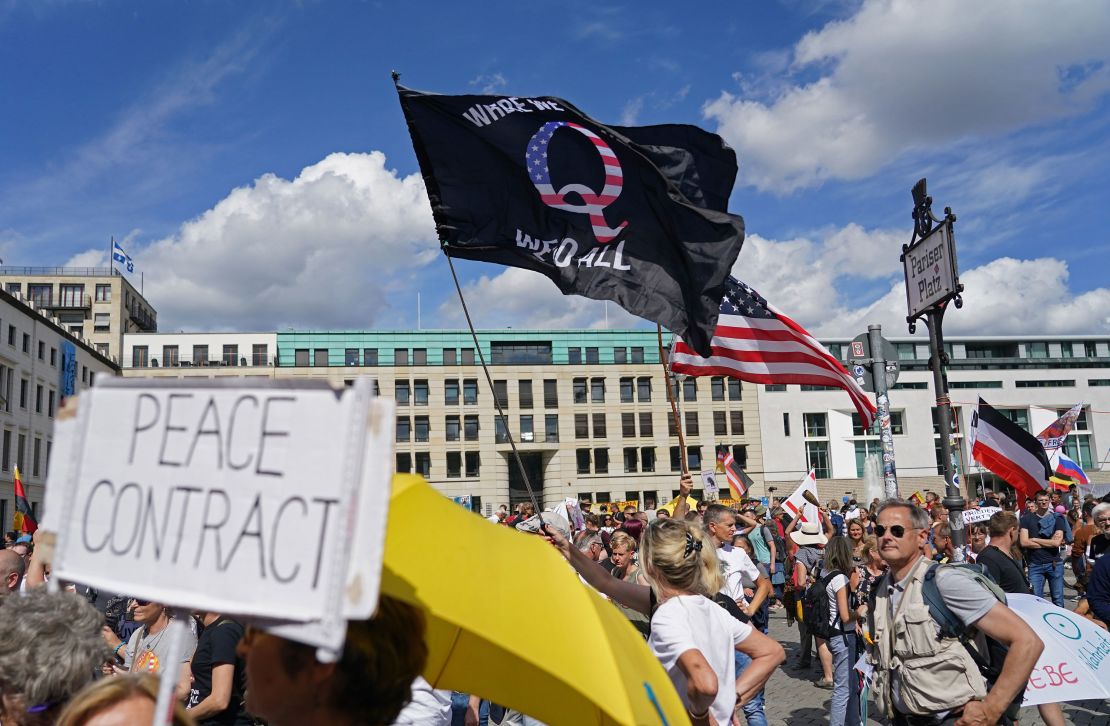 A man waves a QAnon flag at a protest against Covid restrictions in Berlin on August 29, 2020. 