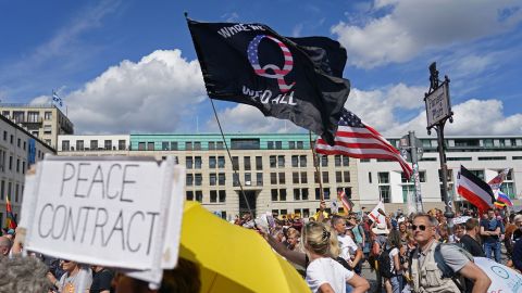 A man waves a QAnon flag at a protest against Covid restrictions in Berlin on August 29, 2020. 