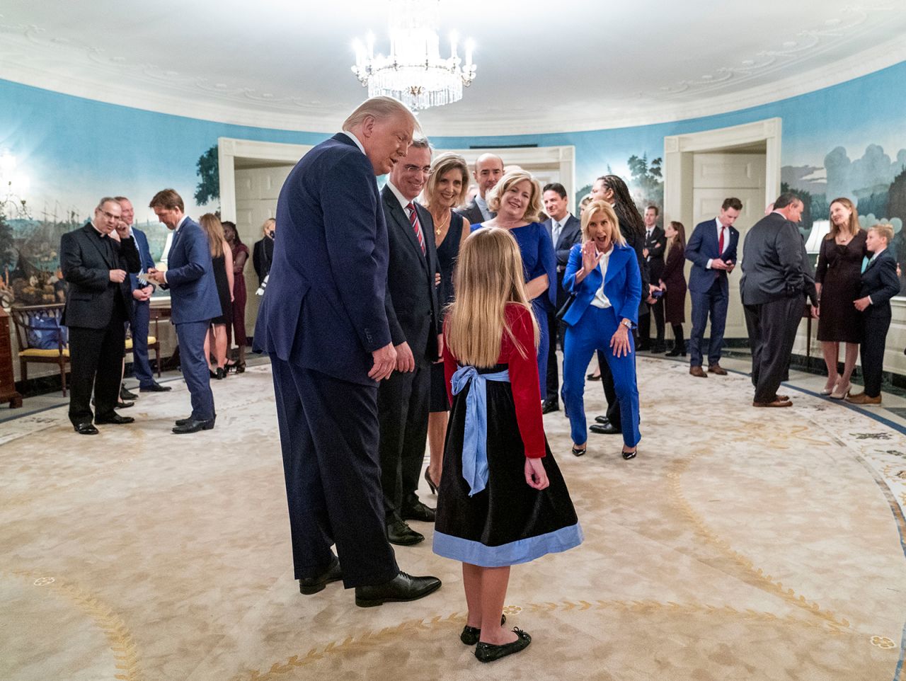 One of Barrett's daughters has several people's attention, including the President's, during the White House reception. On the left side of the photo, looking down in the blue suit, is Nebraska Sen. Ben Sasse, who tested negative for the virus, according to his office. Former New Jersey Gov. Chris Christie, who like the Trumps has tested positive, is seen at right talking to Barrett. <em>CORRECTION: </em><em>This caption has been updated to correctly state that Sen. Ben Sasse tested negative for coronavirus.</em>