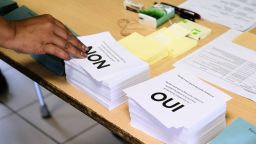 A person picks up a voting form as he prepares to cast his vote at a polling station in the referendum on independence on the French South Pacific territory of New Caledonia in Noumea on October 4, 2020. - The French South Pacific territory of New Caledonia votes in an independence referendum on October 4, 2020, which is expected to reject breaking away from France after almost 170 years despite rising support for the move. (Photo by Theo Rouby / AFP) (Photo by THEO ROUBY/AFP via Getty Images)