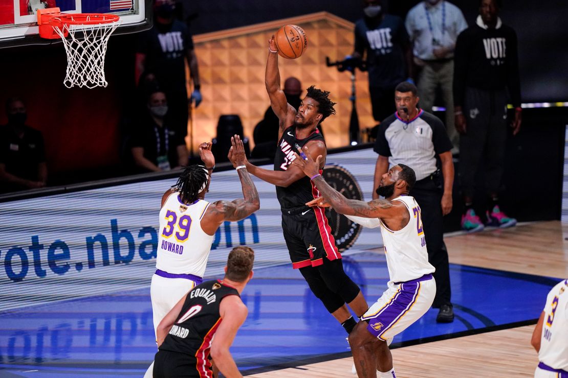 Miami Heat's Jimmy Butler (22) passes the ball against Los Angeles Lakers' Dwight Howard (39) and Los Angeles Lakers' LeBron James (23) during Game 3 of basketball's NBA Finals.