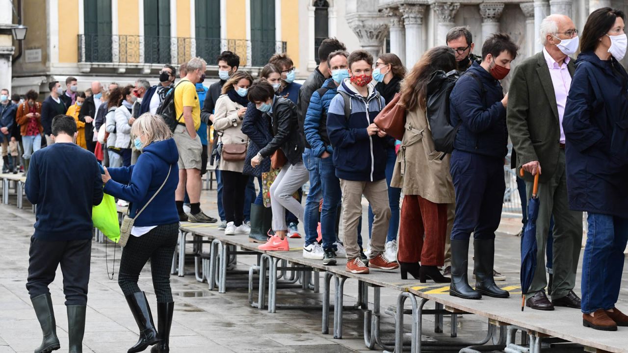 People walk across elevated walkways outside St. Mark's Basilica on St. Mark's square in Venice as the flood barriers are tested.