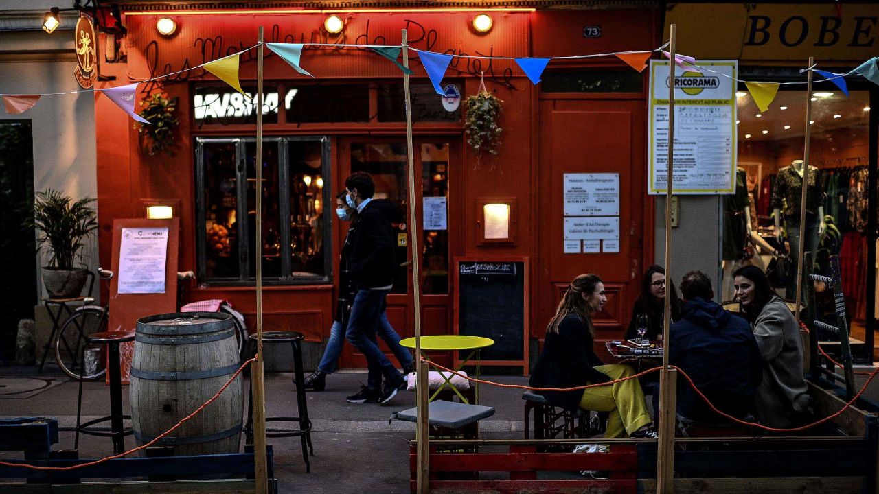 People have drinks as they sit on the terrace of a bar in the French capital, Paris, on October 3, 2020.