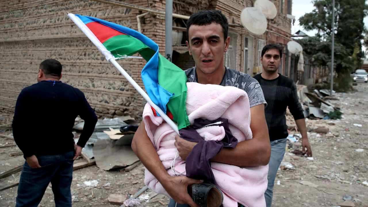 A man brings out his belongings after his house was shelled in Gyandzha, Azerbaijan.