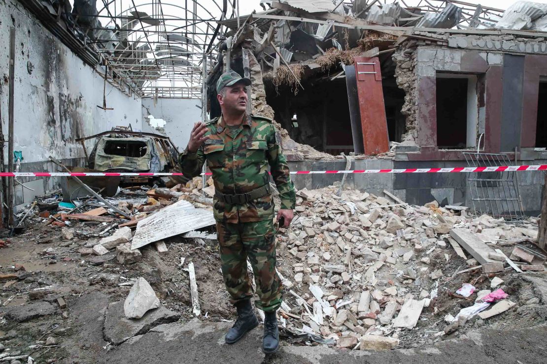 A serviceman stands in front of a building allegedly damaged by shellfire in Gyandzha in Azerbaijan.