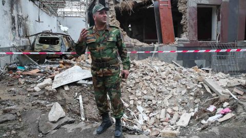 A serviceman stands in front of a building allegedly damaged by shellfire in Gyandzha in Azerbaijan.