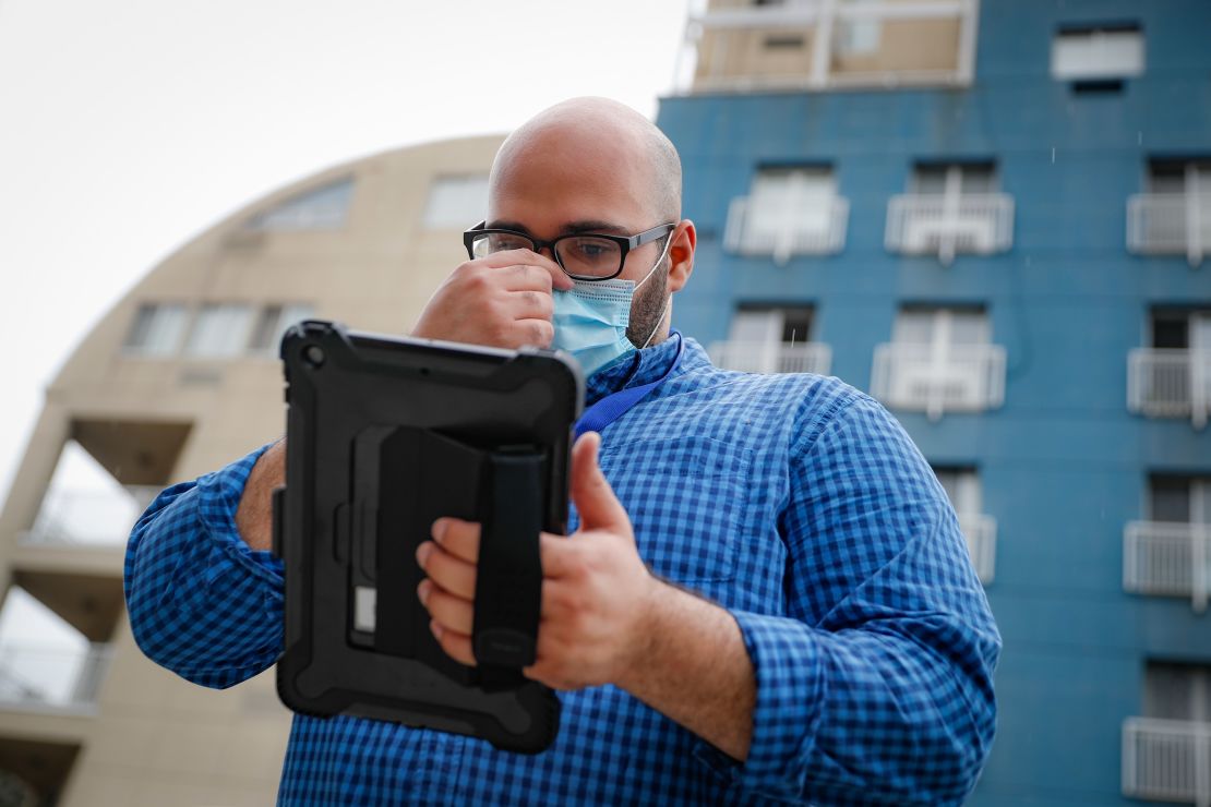 Contact tracer Joseph Ortiz gathers information as he heads to a potential patient's home in New York City. The city has hired more than 3,000 tracers, and as of August met its goal of reaching about 90% of all newly diagnosed people and completing interviews with 75%.