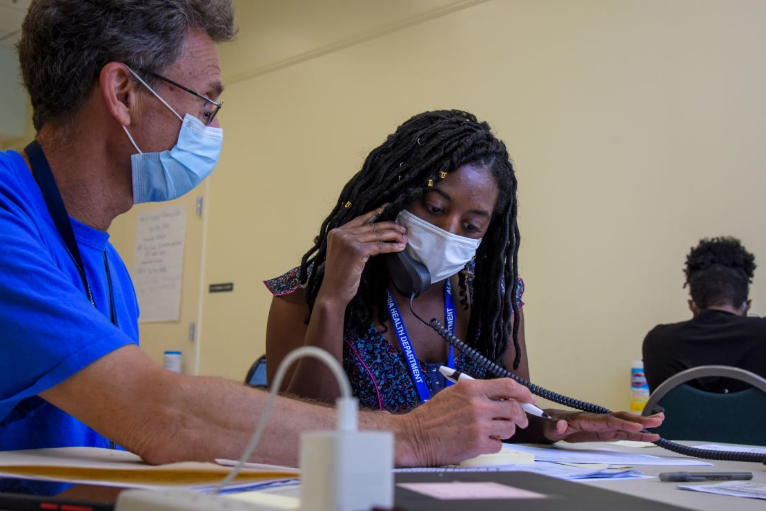 Michael Spatz, left, a volunteer in Alexandria, Virginia, helps AshaLetia Henderson through her first positive-case call as a coronavirus contact tracer. 