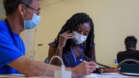Michael Spatz, left, a volunteer in Alexandria, Virginia, helps AshaLetia Henderson through her first positive-case call as a coronavirus contact tracer. 