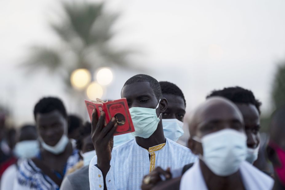 A man from the Mouride Brotherhood reads a book with poems written by Cheikh Amadou Bamba as he stands in line to enter the Grand Mosque of Touba in Touba, Senegal, on October 5. 