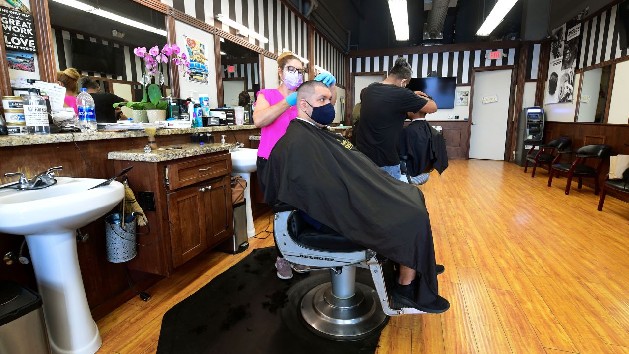 Hairdressers work with customers seated inside for the first time in months in September at Angelo's Barber Shop in downtown Los Angeles.