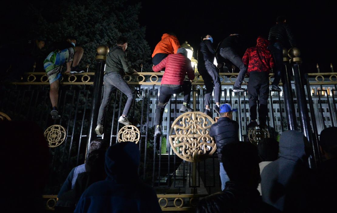 Protesters attempt to break through the gates of government headquarters in Bishkek on Monday.