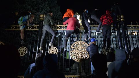 Protesters attempt to break through the gates of government headquarters in Bishkek on Monday.
