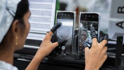 An employee tests the camera quality of mobile phones on an assembly line in the mobile phone plant of Rising Stars Mobile India Pvt., a unit of Foxconn Technology Co., in Sri City, Andhra pradesh, India, on Thursday, July 11, 2019. Foxconn, also known as Hon Hai Precision Industry Co., opened its first India factory four years ago, it now operates two assembly plants with plans to expand those and open two more. The company was integral to Chinas transformation into a manufacturing colossus, and founder Terry Gou has told India's Prime Minister Narendra Modi that Foxconn could help India do the same. Photographer: Karen Dias/Bloomberg via Getty Images