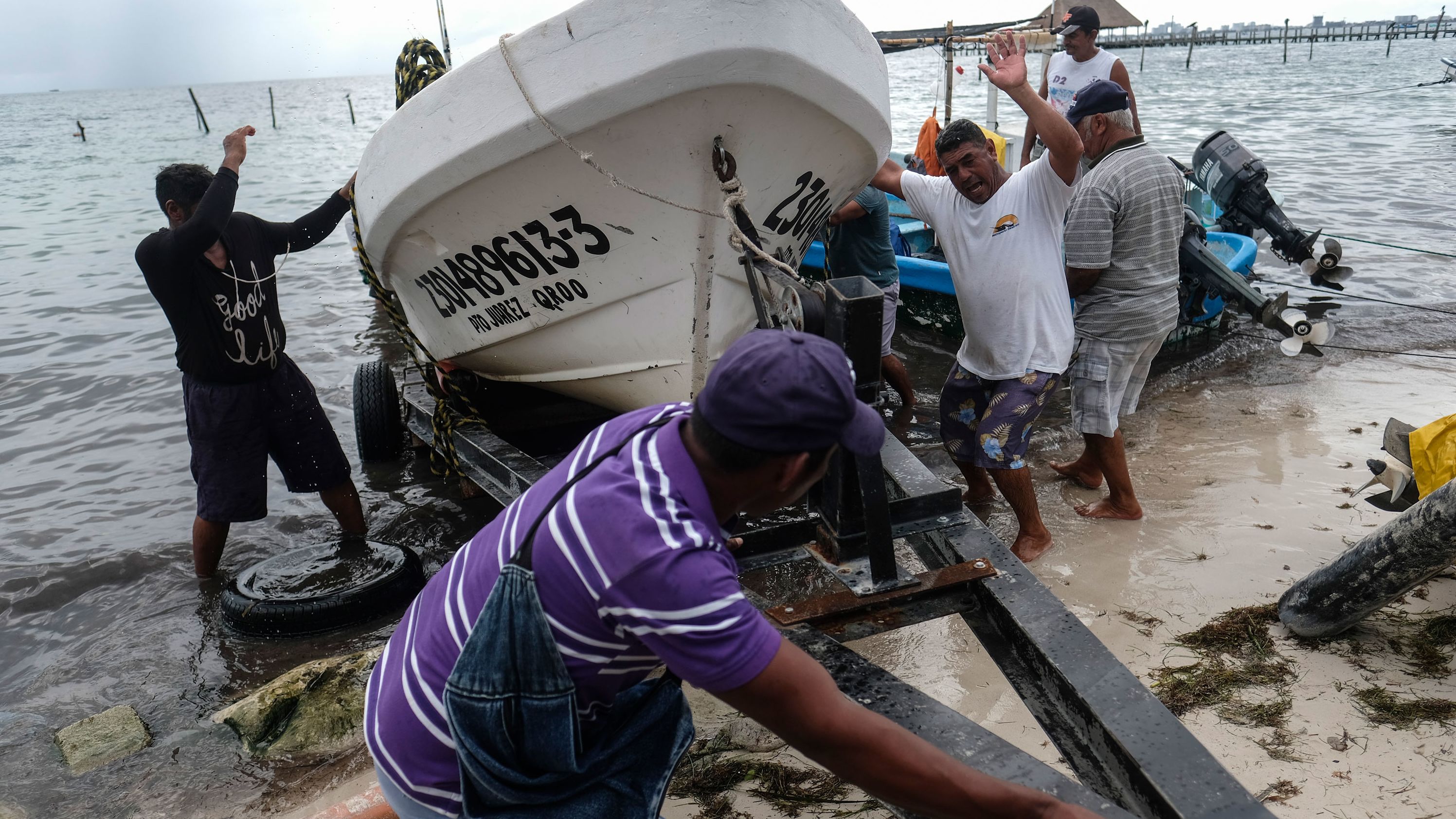 Fishermen pull in a boat from the water in anticipation of Hurricane Delta in Puerto Juarez, Cancun, on October 6.