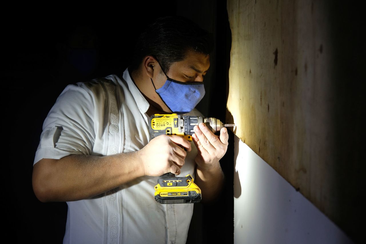 A hotel worker from the Fiesta Americana Condesa resort covers a window with plywood at a shelter set up at the Technological Institute of Cancun, on October 6.