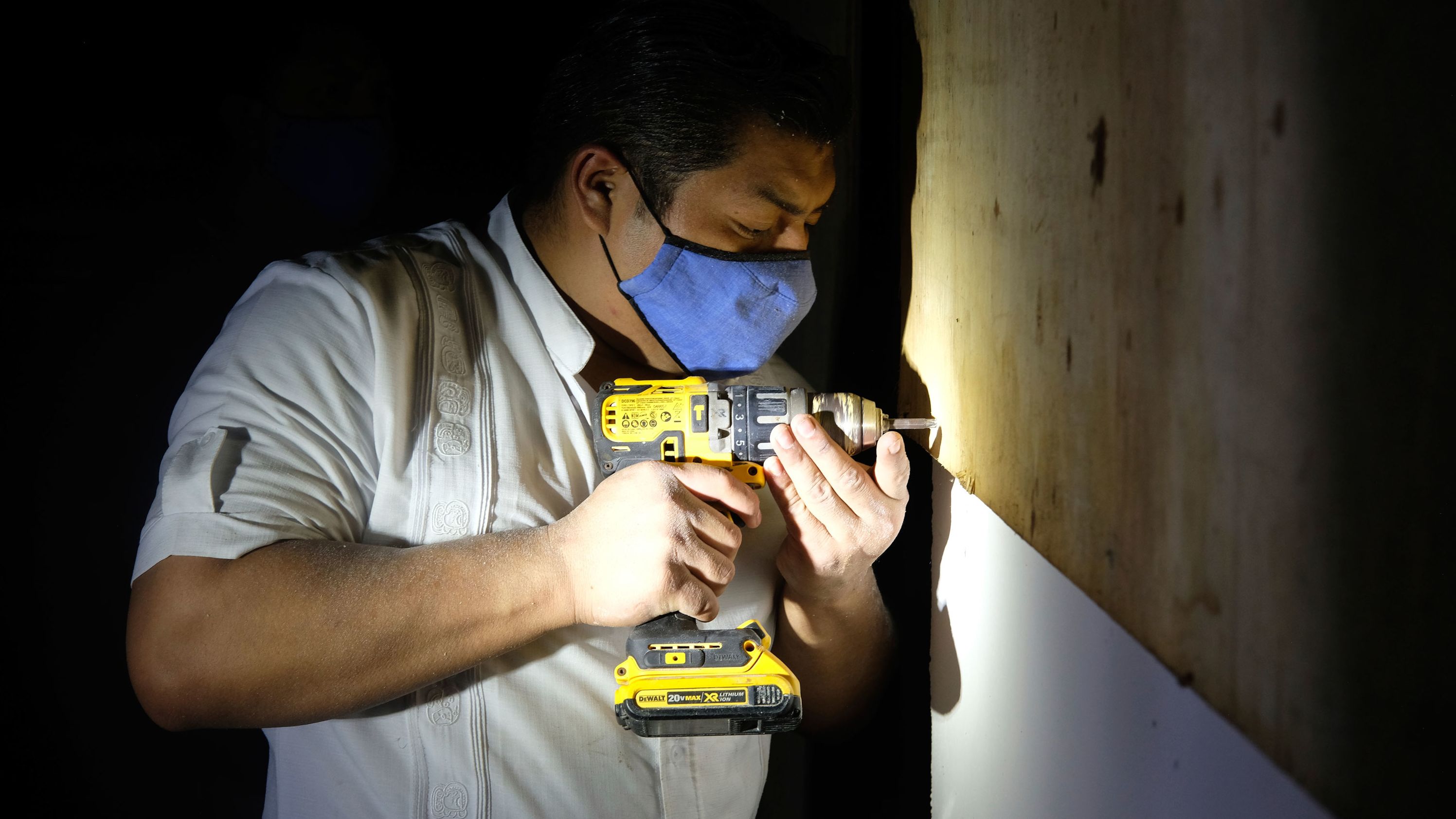 A hotel worker from the Fiesta Americana Condesa resort covers a window with plywood at a shelter set up at the Technological Institute of Cancun, on October 6.