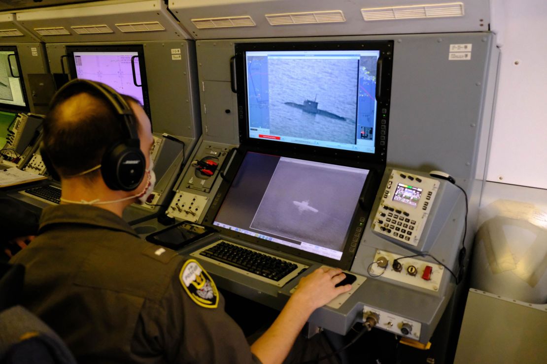 A US Navy service member uses the P-8A's camera to track track a Russian Kilo-class submarine as it sails through the Black Sea.