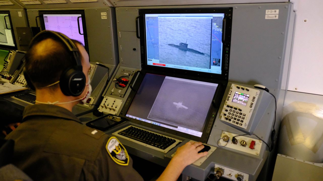 A US Navy service member uses the P-8A's camera to track track a Russian Kilo-class submarine as it sails through the Black Sea.