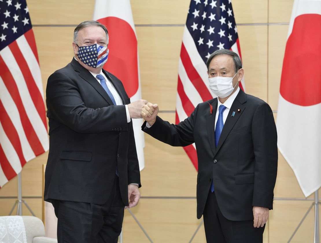 Newly elected Japanese Prime Minister Yoshihide Suga (R) and US Secretary of State Mike Pompeo bump fists at the prime minister's office in Tokyo on Oct. 6, 2020.