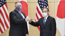 Japanese Prime Minister Yoshihide Suga (R) and U.S. Secretary of State Mike Pompeo bump fists at the prime minister's office in Tokyo on Oct. 6, 2020, wearing face masks amid continued worries over the novel coronavirus. (Photo by Kyodo News via Getty Images)