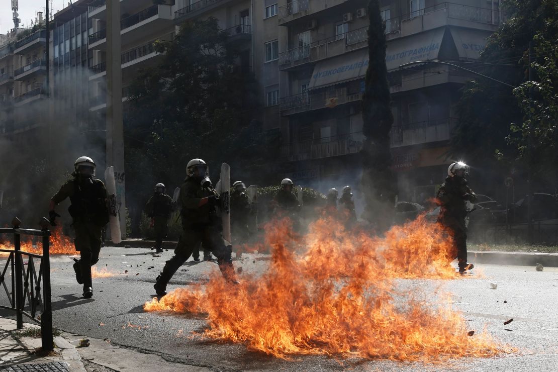 Riot policemen try to avoid flames from a petrol bomb thrown by protesters on Wednesday.