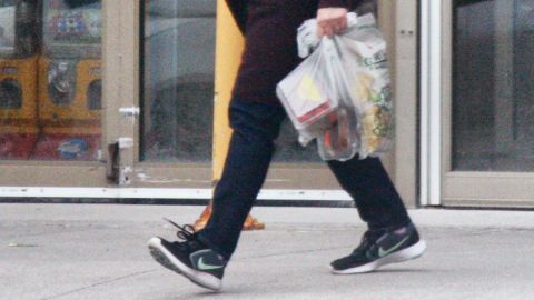 A woman in Toronto carries her groceries in plastic bags on April 24, 2020.