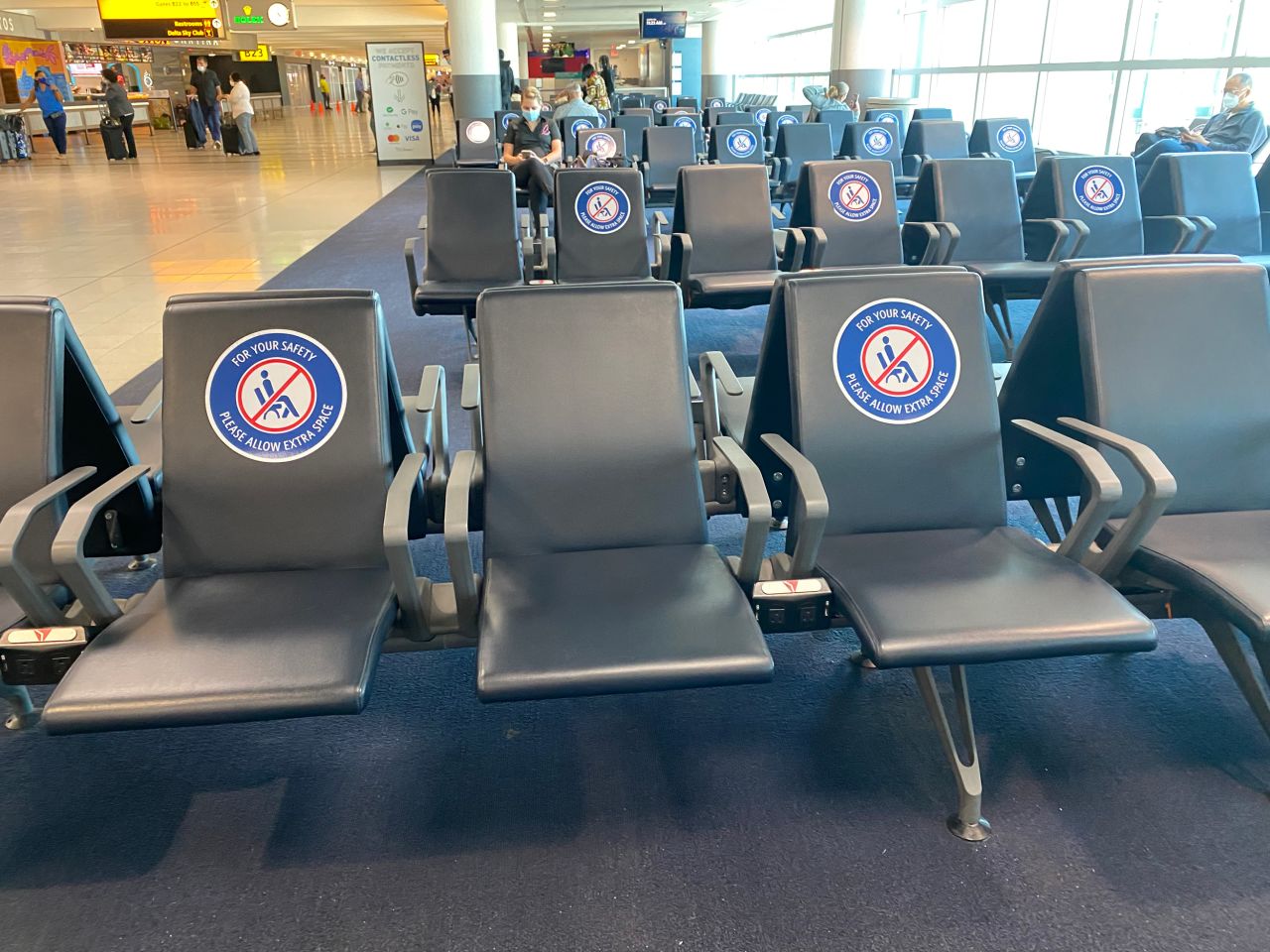 Seats outside the gates instruct travelers to abide by social distancing protocols.
