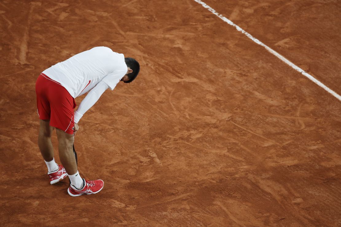 Djokovic leans on his racket in the quarterfinal match against Carreno Busta.