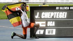 Ugandan athlete Joshua Cheptegei waves an Uganda national flag as he celebrates after breaking the 10,000m track world record during the NN Valencia World Record Day at the Turia stadium in Valencia on October 7, 2020. - Joshua Cheptegei broke the 10,000m track world record today in Valencia with a time of 26mins 11seconds. He lowered the previous mark of 26min 17.53s set by Kenenisa Bekele in 2005 in Brussels. This was the 24-year-old 10,000m world champion's third world record this year. (Photo by JOSE JORDAN / AFP) (Photo by JOSE JORDAN/AFP via Getty Images)