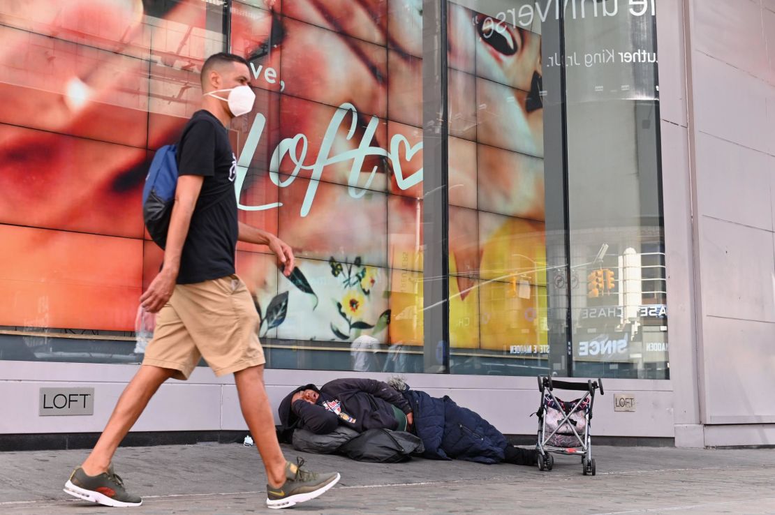 A homeless person sleeps in front of a store at Time Square on September 28, 2020 in New York City.