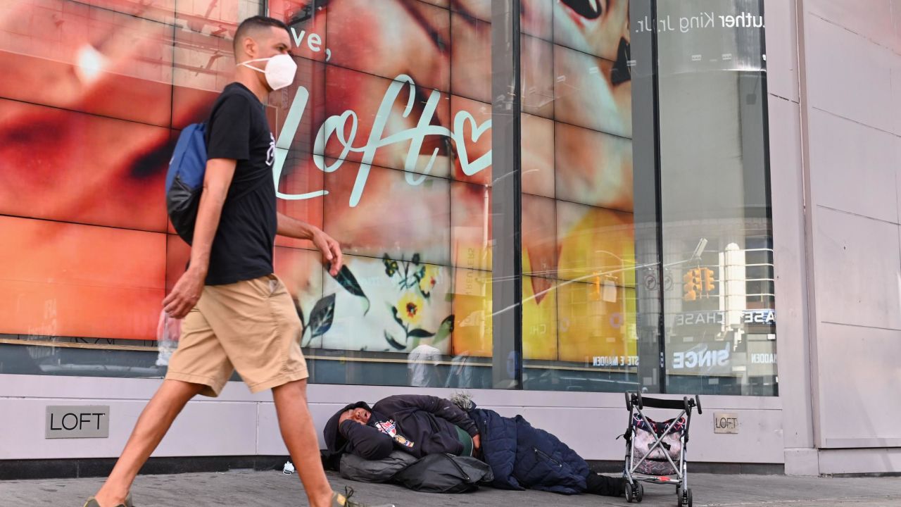 A homeless person sleeps in front of a store at Time Square on September 28, 2020 in New York City.