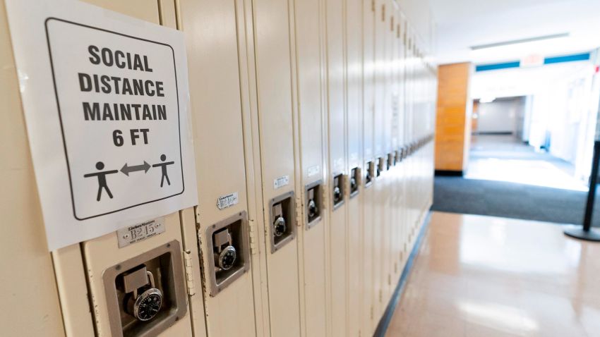 FILE - In this Aug. 28, 2020, file photo, a sign that reads "Social Distance Maintain 6 ft" is posted on student lockers at a school in Baldwin, N.Y. The coronavirus is infecting a rising number of American children and teens in a trend authorities say appears driven by school reopenings and the resumption of sports, playdates and other activities. (AP Photo/Mark Lennihan, File)