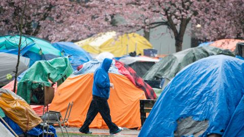 A man walking through a Vancouver tent city in March. Researchers in a new study found that homeless people who received direct cash transfers were able to find stable housing faster.
