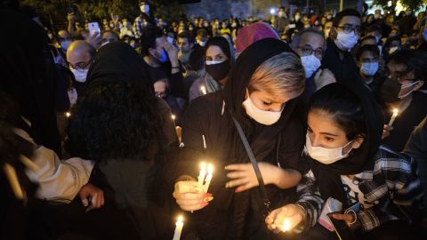 Iranian women hold candles as they gather in front of the Jam hospital in central Tehran.