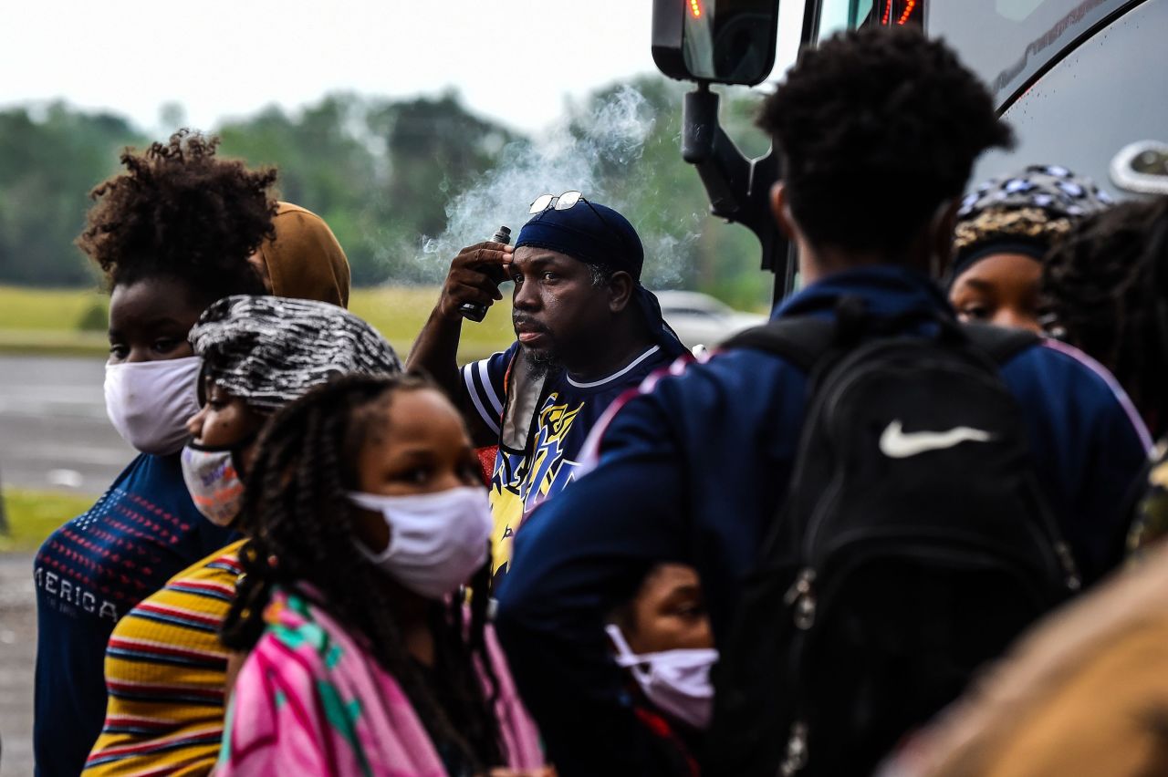 People line up to board a bus for evacuation before the arrival of hurricane Delta in Lake Charles, Louisiana, on Thursday, October 8.