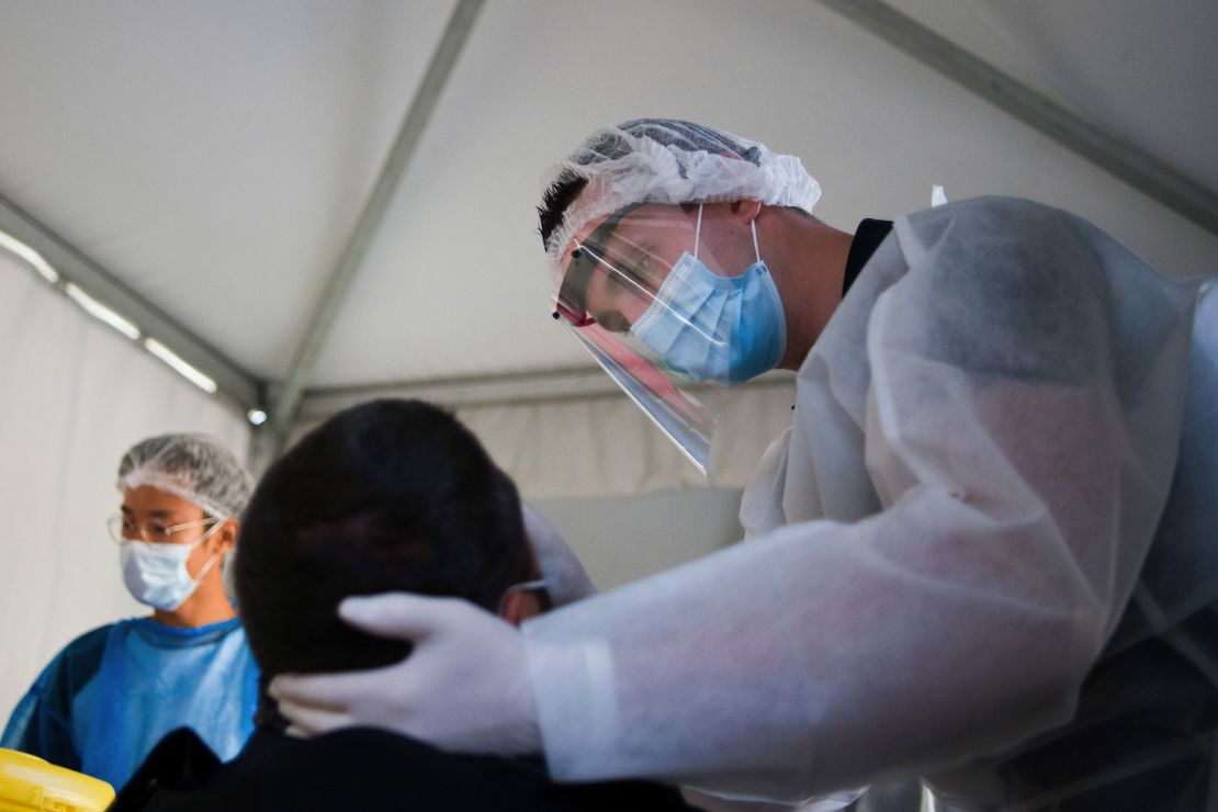 A medic administers a Covid-19 swab test on a patient in a pop-up testing tent in Paris, France.