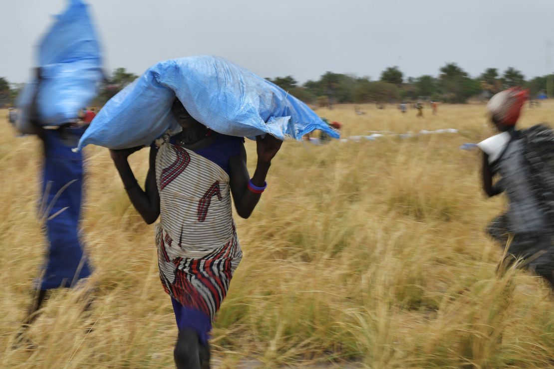Villagers collect food aid dropped from a World Food Programme plane to a village in Ayod county, South Sudan, in February 2020. 
