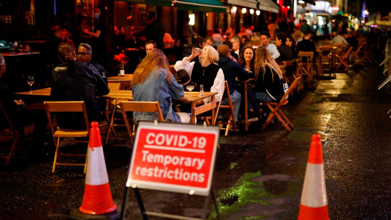 People drink at the outside tables of a cafe in Soho, in central London on September 23, 2020. - Britain on Tuesday tightened restrictions to stem a surge of coronavirus cases, ordering pubs to close early and advising people to go back to working from home to prevent a second national lockdown. (Photo by Tolga Akmen / AFP) (Photo by TOLGA AKMEN/AFP via Getty Images)